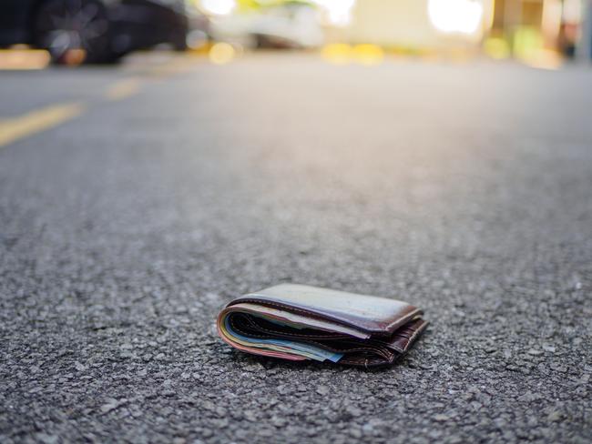 wallet with money drop on the street, lost money concept, copy space on top