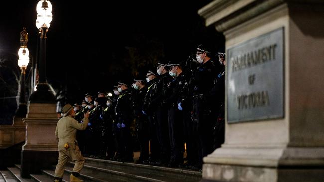 An anti-lockdown protester approaches police outside parliament. Picture: AFP