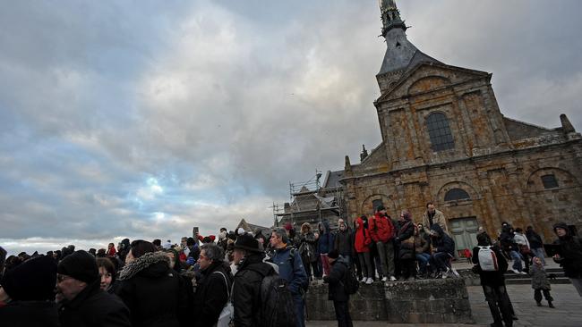 People flock to ‘Mascaret’ in front of the abbey church on the top of the Mont-Saint-Michel, on March 21. Pic: AFP/Guillaume Souvant