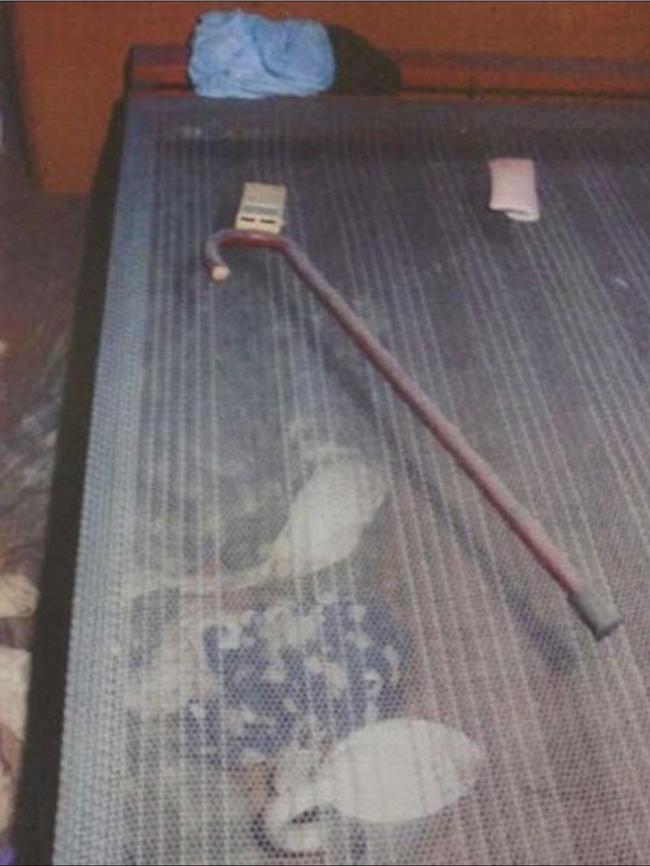 A walking stick covered in dust lies on the frame of a bed. Picture: NSW Coroner's Court