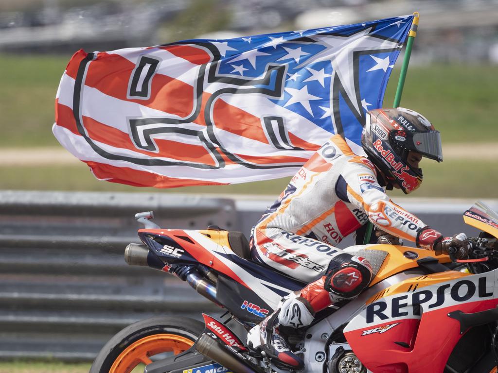 Marc Marquez dari Spanyol dan Repsol Honda Team merayakan dengan mengibarkan bendera kemenangan.
