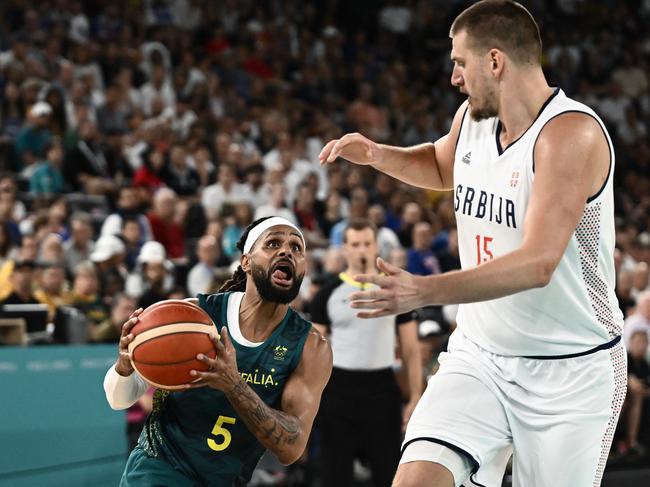 Patty Mills works around Nikola Jokic. Mills did everything he could to get Australia over the line. Picture: Aris Messinis / AFP