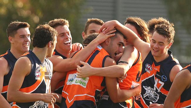 John Roumeliotis is mobbed by his teammates after kicking a goal on debut. Picture: Graham Denholm.