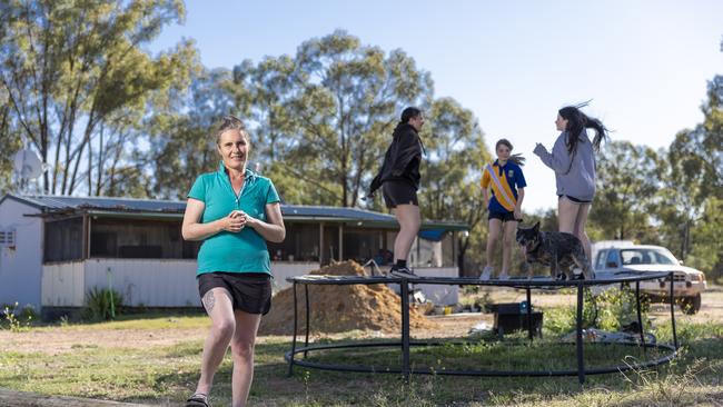 Jane Rampling with daughters Bianca and Zoe Spencer, 15 and 12, and Tiani Brassel, 15, (and Tradie the blue heeler) on their block at Tara. Picture: Mark Cranitch.