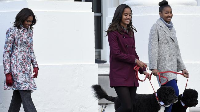 The kids are all right: First lady Michelle Obama follows her daughters Malia and Sasha to welcome the Official White House Christmas tree. Pic: AP Photo/Susan Walsh