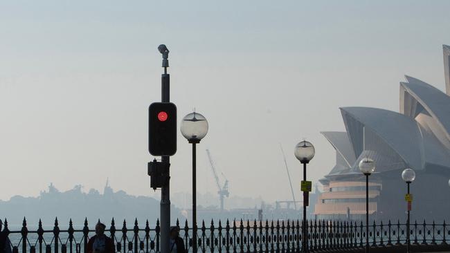 The Sydney Opera House is seen shrouded by smoke on September 13, 2023, as a smoky haze blankets Australia's scenic Sydney Harbour, after a ring of controlled blazes burned on the city's fringes in preparation for the looming bushfire season. (Photo by Steve CHRISTO / AFP)