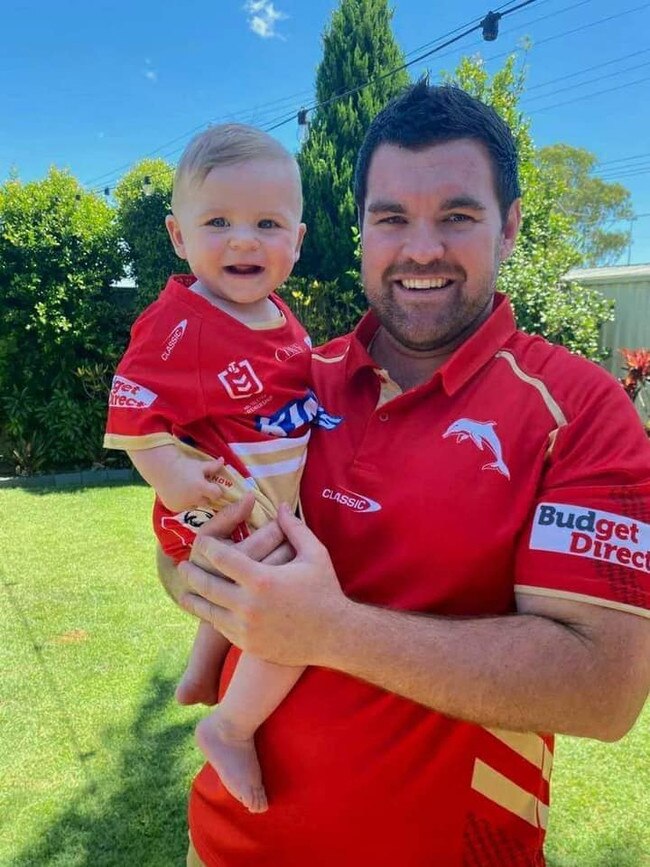 Ben Webb, 32, and son Patrick, 9-months-old, of Kippa-Ring at the Dolphins inaugural NRL game against the Sydney Roosters at Brisbane's Suncorp Stadium on Sunday, March 5, 2023. Ben is the grandson of long-term Redcliffe Dolphins president, Des Webb. Picture: Supplied
