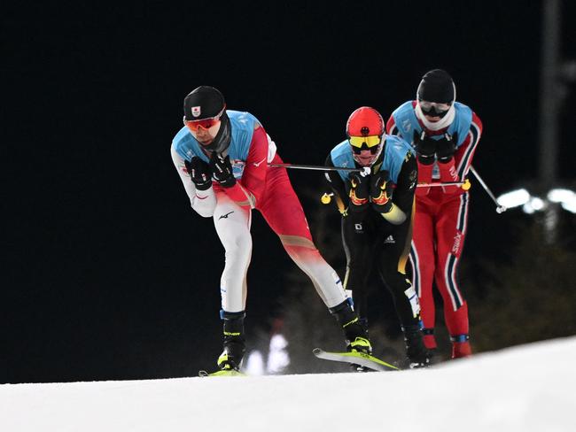 (From L) Japan's Akito Watabe, Germany's Manuel Faisst and Norway's Jarl Magnus Riiber compete in the cross-country race of the Nordic Combined men's individual large hill/10km event during the Beijing 2022 Winter Olympic Games at the Zhangjiakou National Cross-Country Skiing Centre on February 15, 2022. (Photo by Christof STACHE / AFP)