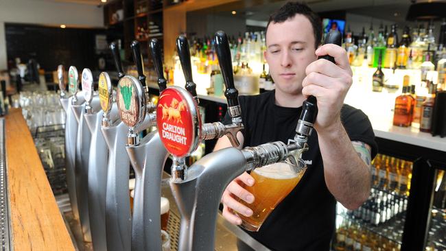 Barman Chris Turpin pulling a beer at Precinct Hotel, Richmond.