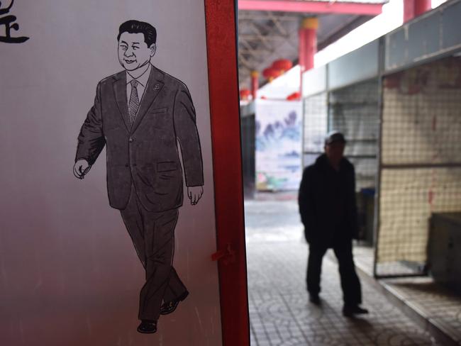 A poster of Chinese President Xi Jinping at a market in Beijing. China's propaganda machine kicked into overdrive to defend the Communist Party's move to scrap presidential term limits. Picture: AFP/Greg Baker