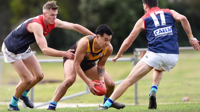 Thomastown’s Michael Tang takes on two Diamond Creek defenders. Picture: Steve Tanner