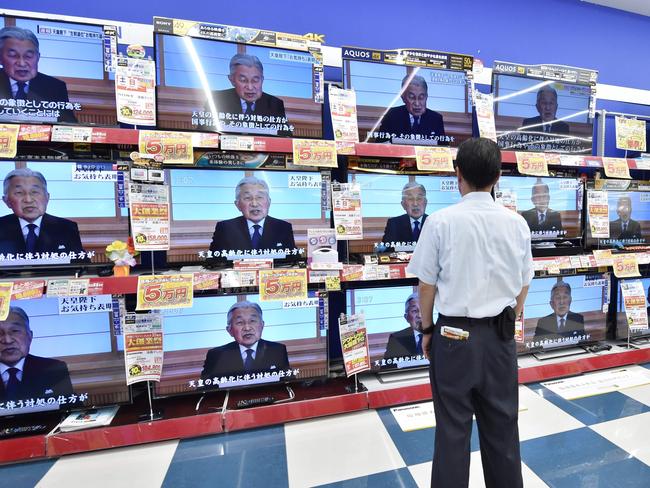 A man looks at television screens showing a speech by Japanese Emperor Akihito to the nation. Picture: AFP.