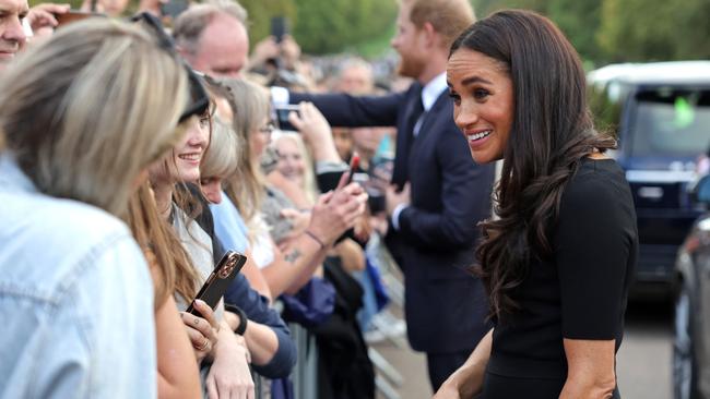 WINDSOR, ENGLAND - SEPTEMBER 10: Meghan Duchess of Sussex speaks with well-wishers at Windsor Castle on September 10, 2022 in Windsor, England. Crowds have gathered and tributes left at the gates of Windsor Castle to Queen Elizabeth II, who died at Balmoral Castle on 8 September, 2022. (Photo by Chris Jackson - WPA Pool/Getty Images)