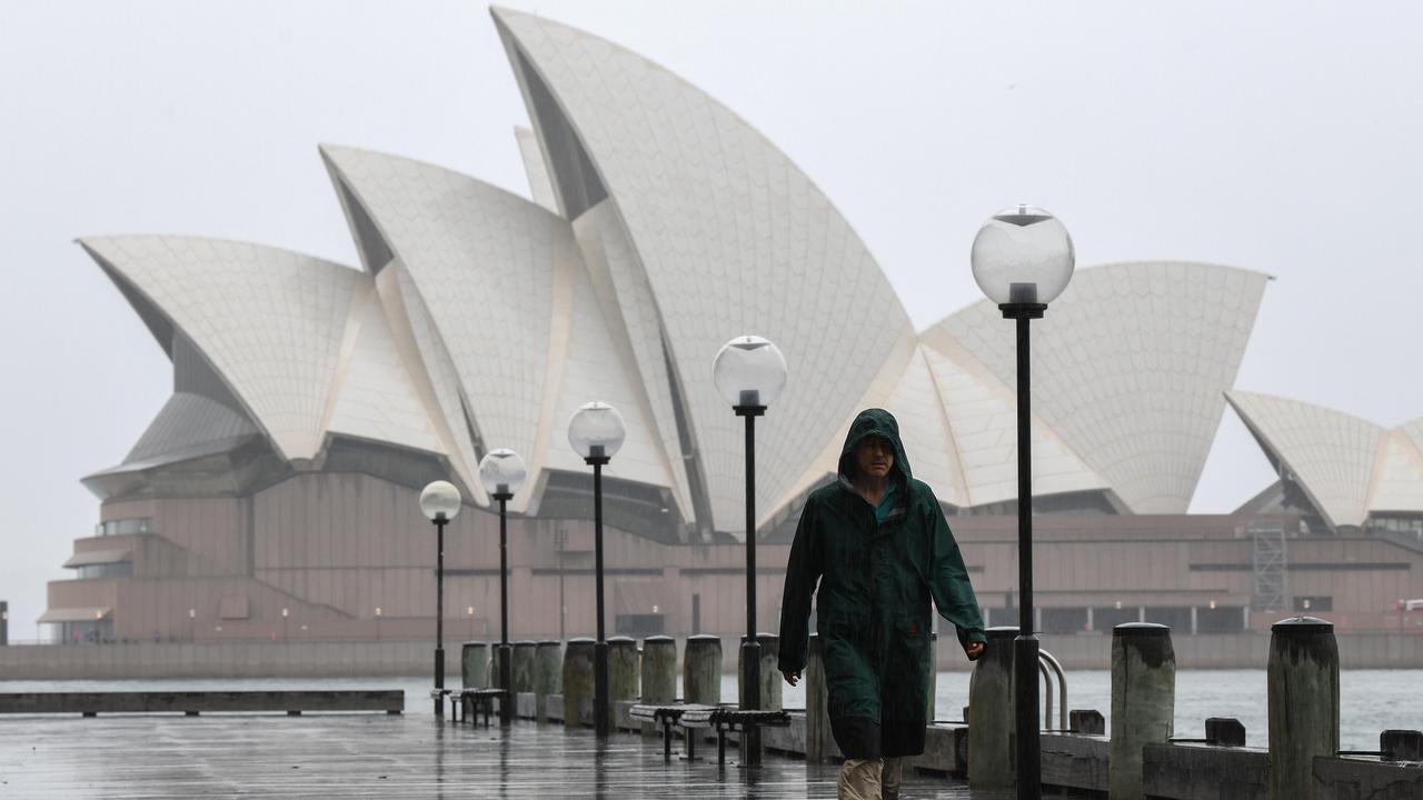 A man braves the wet weather near the Sydney Opera House. Picture: NCA NewsWire/Bianca De Marchi