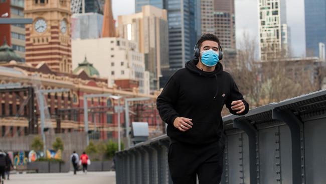 A jogger wears a mask as he crosses Sandridge Bridge on the Southbank in Melbourne. Picture: Paul Jeffers.