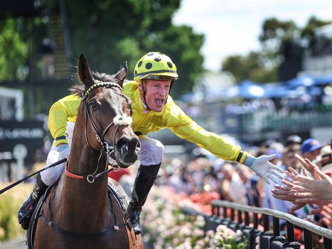 2023 Melbourne Cup Flemington. Running off the Melbourne Cup. Winning jockey Mark Zahra high fives the crowd on race horse Without A Fight on return to scale.     Picture: David Caird