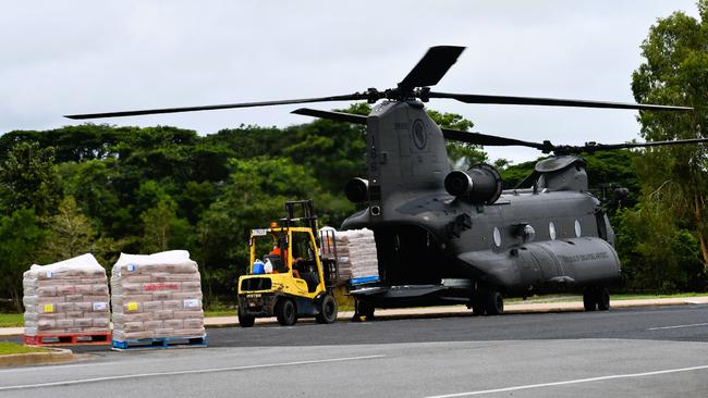 Floody legend Alan Watts working quickly and efficiently to unload four pallets of grocery supplies a Singapore air force CH-47F Chinook Helicopter landing outside Ingham State High School on Sunday. The floods in Hinchinbrook Shire, North Queensland. Picture: Cameron Bates