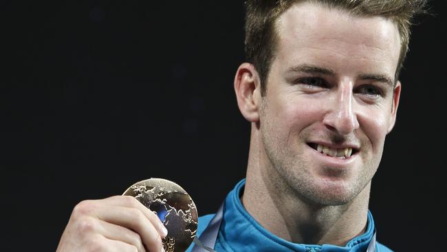 Australia's James Magnussen smiles as he hold the gold medal he won in the Men's 100m freestyle final at the FINA Swimming World Championships in 2013. (AP Photo/Michael Sohn, File)