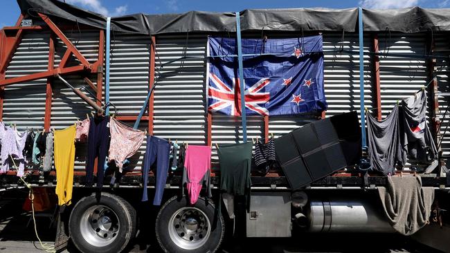 Laundry is hung to dry on the side of a farm truck adorned with a New Zealand flag hung upside-down by demonstrators in Wellington. Picture: AFP