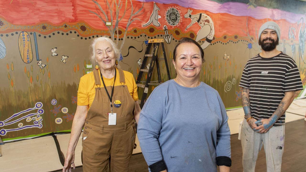 Painting a mural at the community library in Grand Central shopping centre are (from left) Curator – Jennifer Wright (Summers) and Indigenous artists Cheryl Moggs and Aaron (Dhuril) Blades. Picture: Nev Madsen.