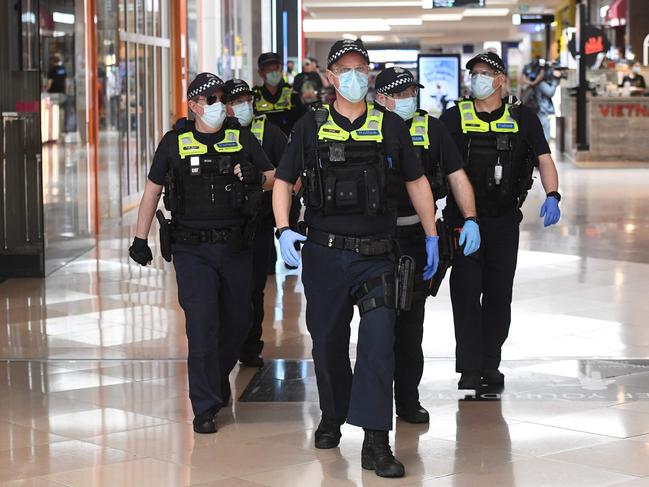 Police patrol through a shopping centre in Melbourne. Picture: AFP