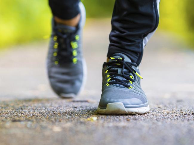 Closeup on shoe of athlete runner man feet running on road