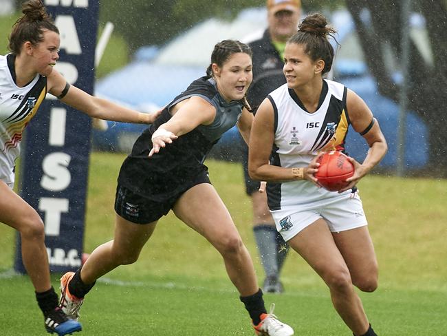 Port Adelaide's Women's Aboriginal AFL Academy side takes on NZ's Kahu Youth development squad on November 24, 2018. WAAA defender Doreena Hansen runs with the ball ahead of Kahu midfielder Kylie McGahan. Photo: Jun Tanlayco.