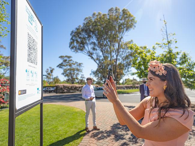 A racegoer scans a QR code upon arrival to Flemington. Picture: Jason Edwards