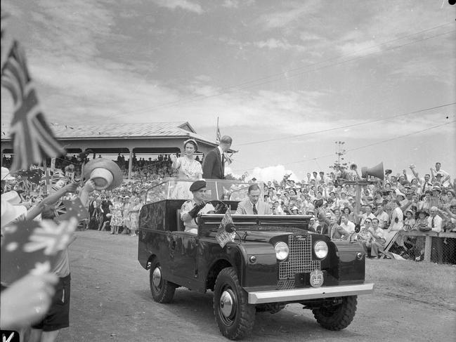 From their Land Rover, the Queen Elizabeth and Duke of Edinburgh Prince Phillip acknowledge the cheers of the children assembled at the schoolchildren's display at Mackay. Photo: The Courier-Mail Photo Archive