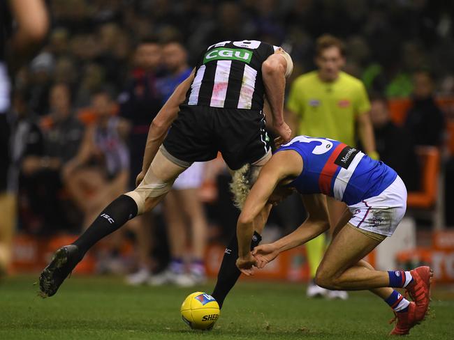 Mason Cox of the Magpies (left) bumps Jason Johannisen of the Bulldogs during the Round 10 AFL match between the Collingwood Magpies and the Western Bulldogs at Etihad Stadium in Melbourne, Friday, May 25, 2018. (AAP Image/Julian Smith) NO ARCHIVING, EDITORIAL USE ONLY