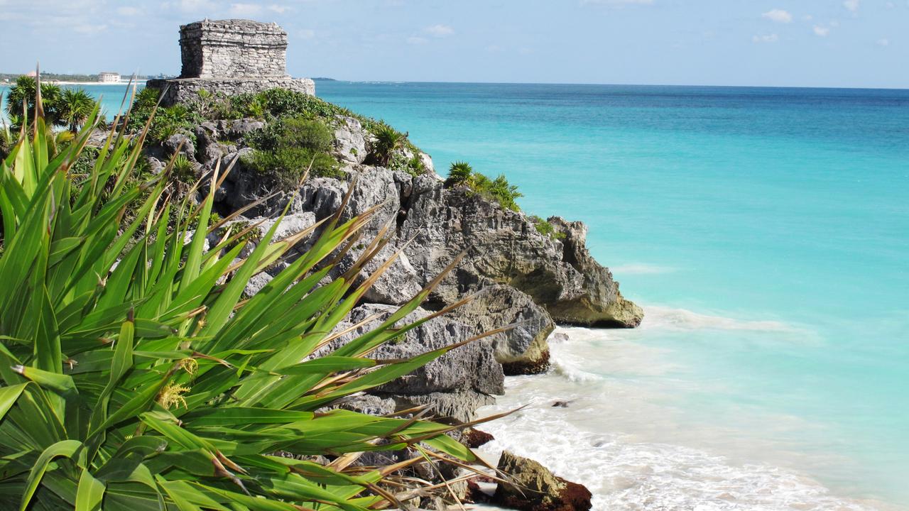 Heaven on earth. The dazzling Caribbean Sea is the backdrop for the ancient Mayan ruins at Tulum Mexico.