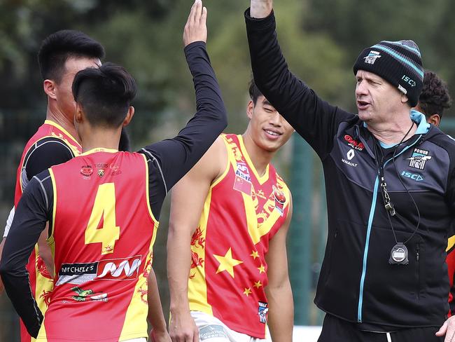 AFL - Port Adelaide Football Club in Shanghai - Day 2. Ken Hinkley gets high fives from the Team China players after participating in a match simulated drill. Picture Sarah Reed