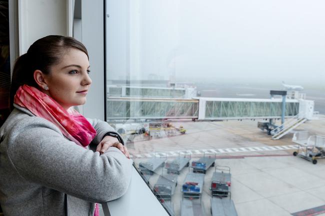 Jade Smith waits for a friend to arrive from Melbourne after flights were delayed. Picture: AAP / Brenton Edwards