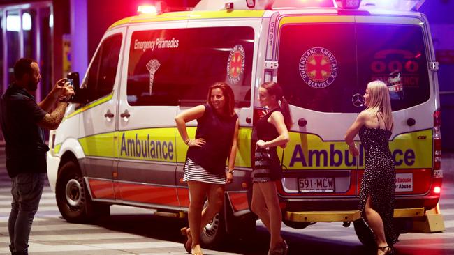 Two women pose for a photo in front of an ambulance parked in the Brunswick Street Mall.