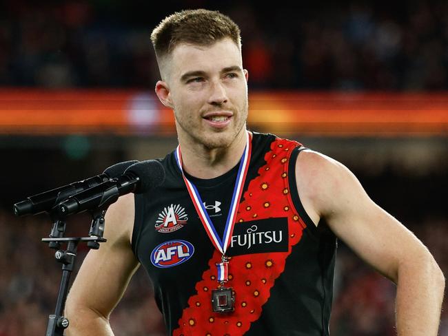 MELBOURNE, AUSTRALIA - APRIL 25: Zach Merrett of the Bombers receives the Anzac Day Medal during the 2024 AFL Round 07 match between the Essendon Bombers and the Collingwood Magpies at the Melbourne Cricket Ground on April 25, 2024 in Melbourne, Australia. (Photo by Dylan Burns/AFL Photos via Getty Images)