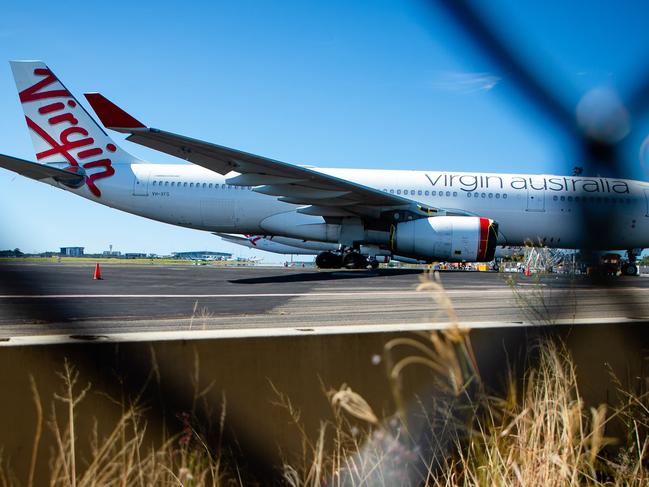 Virgin Australia aircraft are seen parked on the tarmac at Brisbane International airport on April 21, 2020. - Cash-strapped Virgin Australia collapsed on April 21, making it the largest carrier yet to buckle under the strain of the coronavirus pandemic, which has ravaged the global airline industry. (Photo by Patrick HAMILTON / AFP)