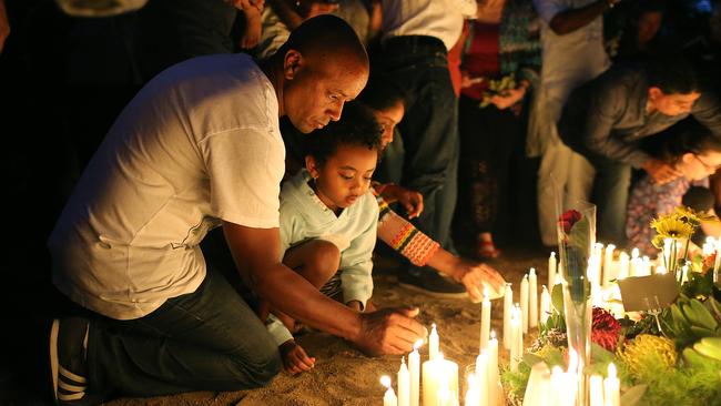 A man and his daughter gather at the Moorooka memorial. Pic: Jack Tran