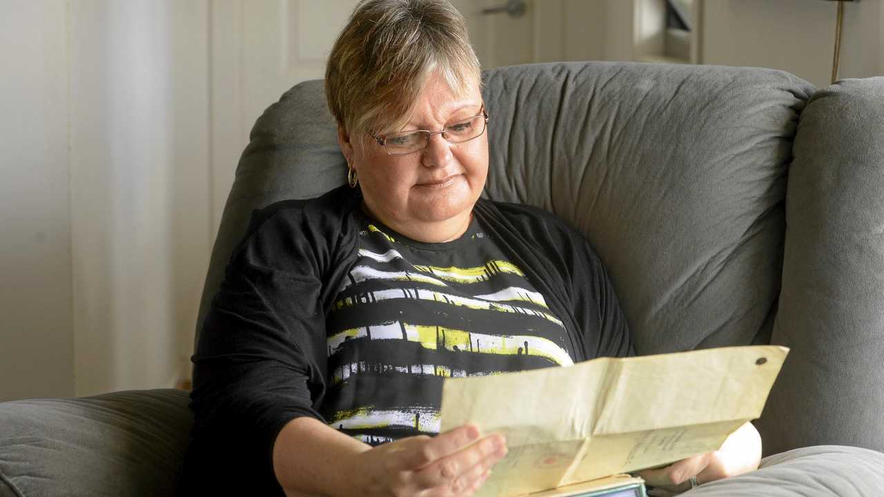 Janene Cleaver (nee Blanch) looks over her original adoption papers that her father gave her on her wedding day. Picture: Caitlan Charles