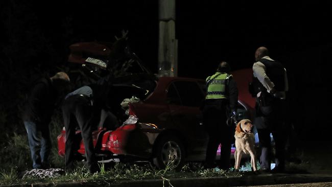 Tasmanian police inspect a car out the front of a Magra property on Back River Road. Picture: Zak Simmonds