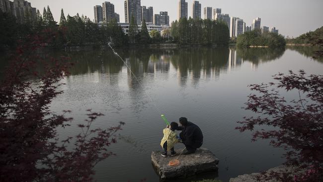 Images of a city waking from a deep sleep: A boy and his grandfather play with a water pistol at East Lake. Picture: Getty Images