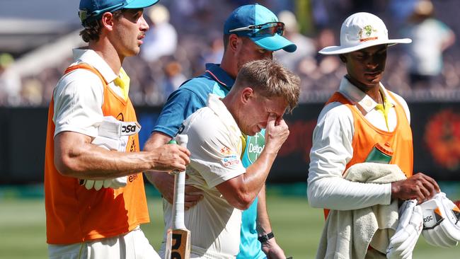 An emotional David Warner is helped off. Picture by Michael Klein