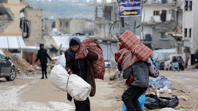 A Palestinian woman carries her belongings as she flees Beit Lahia in the northern Gaza Strip on March 21. Picture: Bashar Taleb / AFP