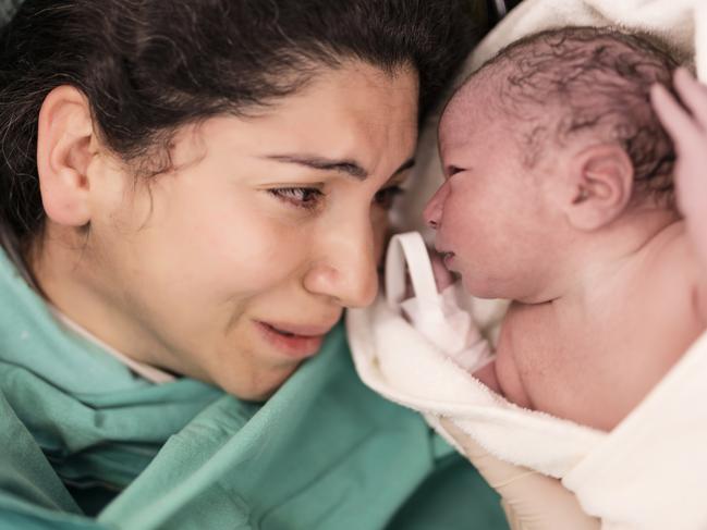 Mother and her newborn baby just after birth in operating room