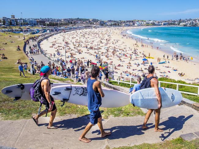 Three surfers heading to the Bondi Beach Bondi beach with their surf boards on a sunny day.Escape 28 April 2024Why I Travel - Carla OatesPhoto: iStock