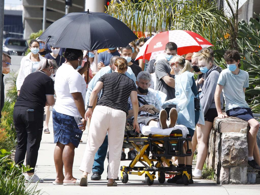 BRISBANE, AUSTRALIA - NewsWire Photos JANUARY 3, 2022: Paramedics tend to a person that fainted while in line for Covid testing at the Royal WomenÃs Hospital in Brisbane. Picture: NCA NewsWire/Tertius Pickard