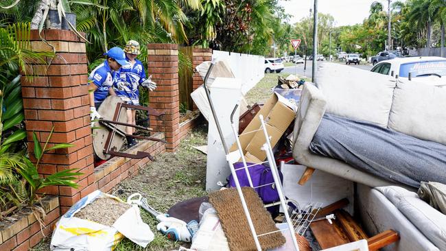 Maliq Wray, 10, and Jake Westmore, 10, of The Brothers Leagues Club help clean up a property that was flooded in Mimosa Street, Holloways Beach. The beachside suburb suffered widespread flooding this week when heavy rain from ex Tropical Cyclone Jasper caused the Barron River to break its banks. Picture: Brendan Radke