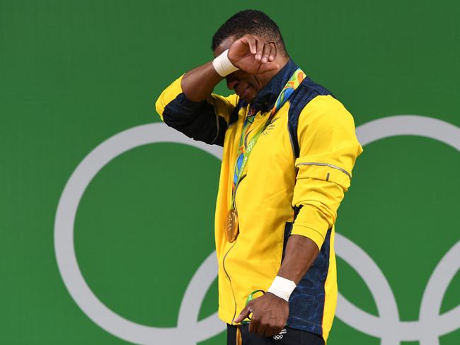 Colombia’s Oscar Albeiro Figueroa Mosquera cries on the podium after he won the Men’s 62kg weightlifting