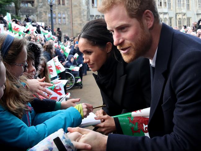 Prince Harry and Meghan Markle shake hands with children as they arrive to a walkabout at Cardiff Castle on January 18, 2018 in Cardiff, Wales. Picture: Getty