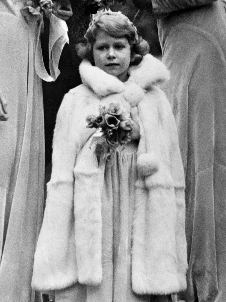 A young Elizabeth takes part in a society wedding in Sussex, England. Her cousin Margaret Rhodes reportedly recalled the future Queen as “a jolly little girl but fundamentally sensible and well behaved”. Picture: Getty