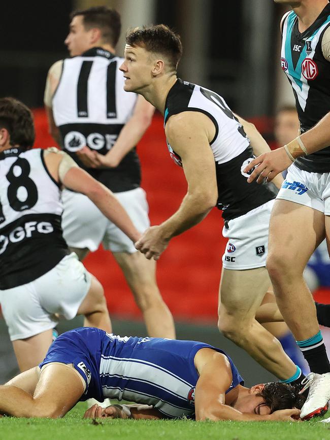 Simpkin lies on the Metricon Stadium grass after being concussed. Pictures: Michael Klein